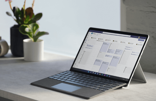 Outlook-Add-in auf einem Surface-Laptop, der auf einem Betontisch neben einer Vase steht